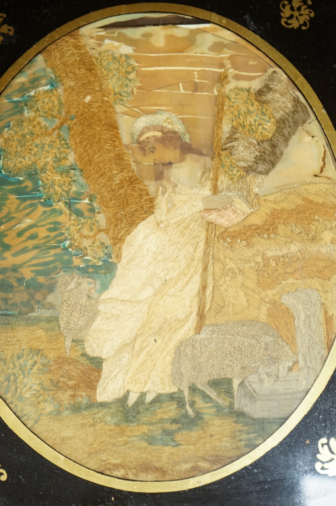 A pair of oval framed early 19th century silk embroideries of a Shepherd and Shepherdess mounted in Verre eglomise glass and gilt frames. Embroideries 28cm high